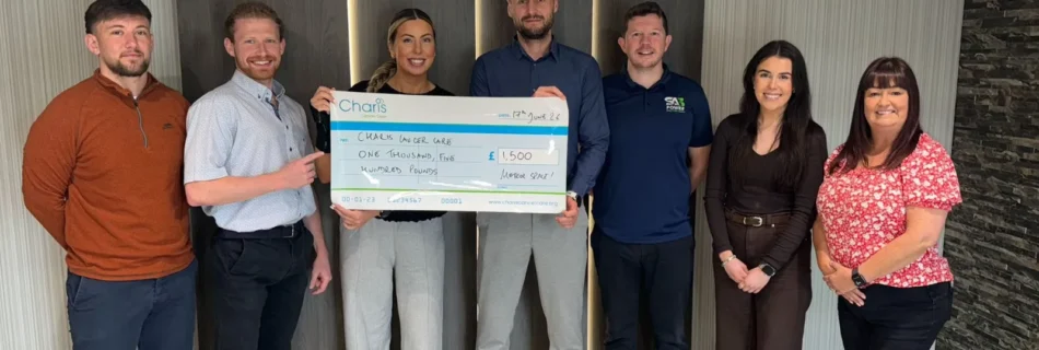 Claire from Charis Cancer Care receiving a £1,500 cheque from the SA3 POWER, Meteor Space and Canary7 Belfast Marathon relay teams