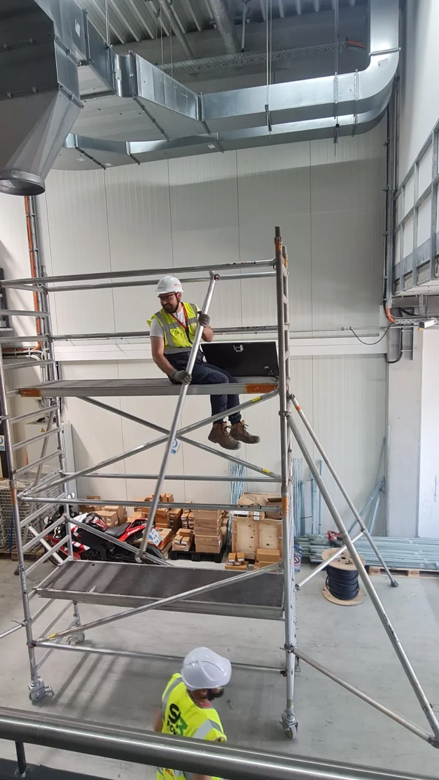 SA3 POWER delegate seated in the trapdoor of a mobile access tower during 3T assembly training in Frankfurt