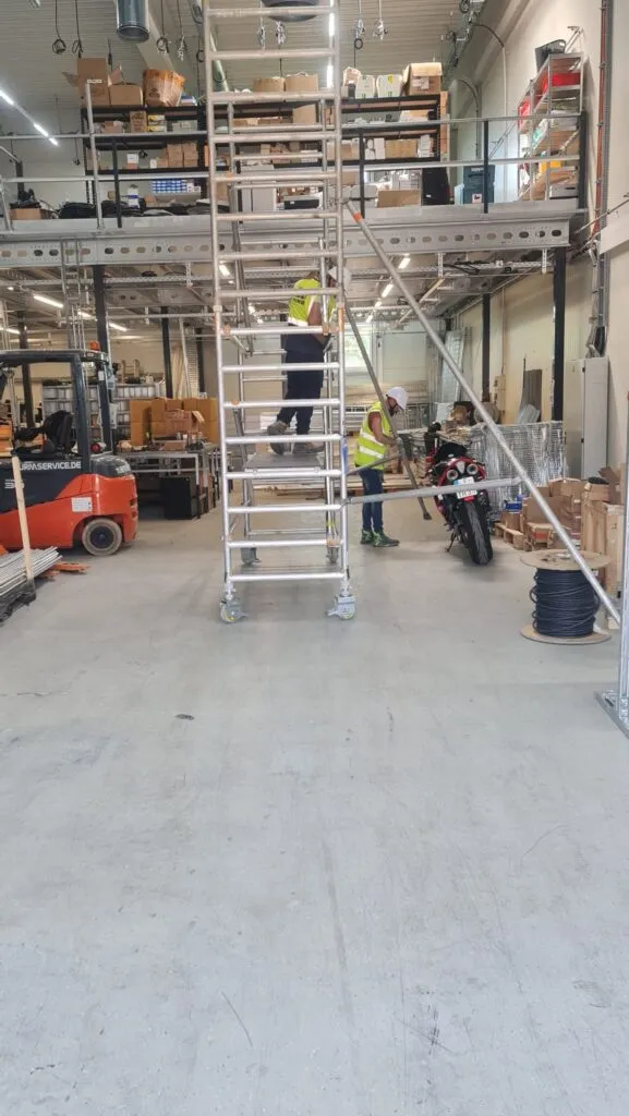 SA3 POWER team assembling a mobile access tower inside the Frankfurt facility