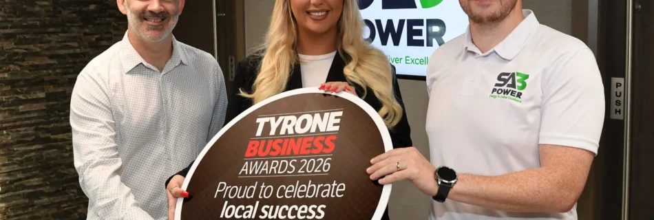 Martin Conway and Holly Cassidy of SA3 POWER with Sean McIntosh of the Tyrone Business Awards holding a Tyrone Business Awards 2026 sign