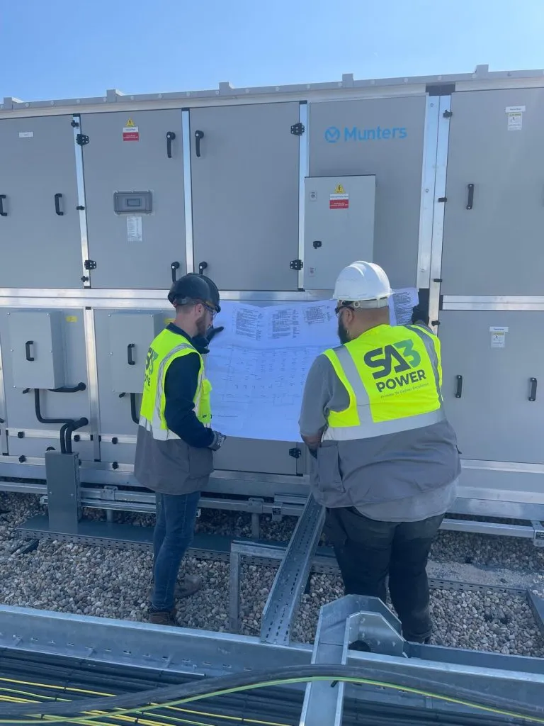 SA3 Power engineers reviewing drawings beside plant equipment