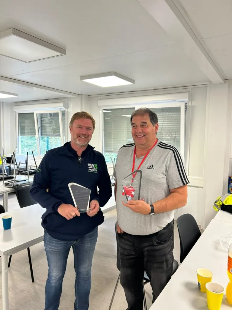 SA3 POWER manager holding a Trade Partner League monthly award alongside the main contractor representative
